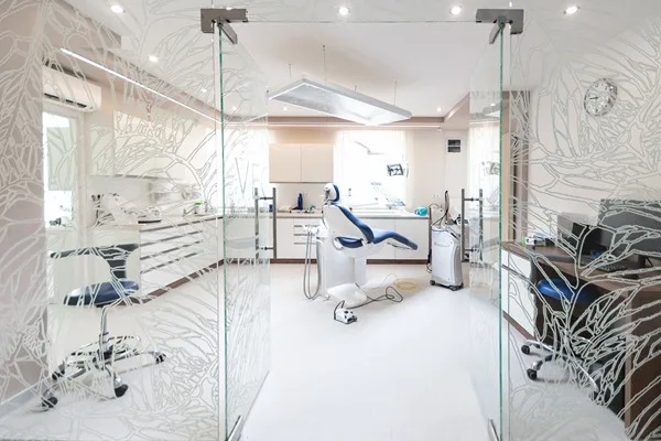 Üvegfallal elválasztott kezelőhelyiségek a mintás Vecsés Dental üvegportállal